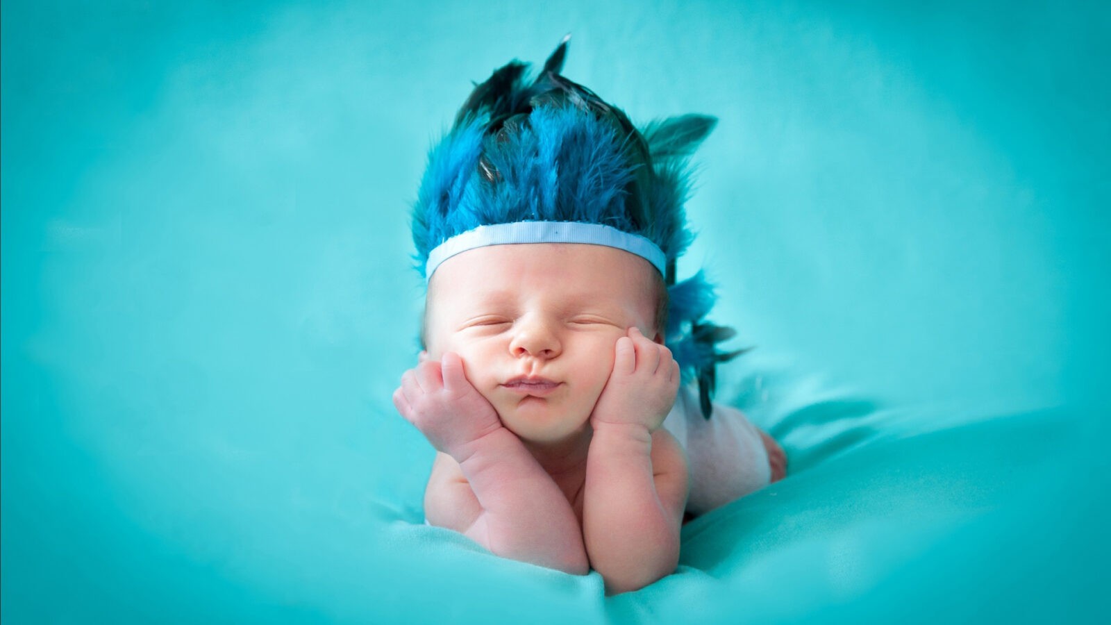 a baby with feathers on its head